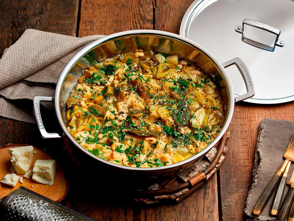 Gryderet af braiseret knoldselleri med hvide bønner, risoni-pasta, porrer, persille og olivenolie
